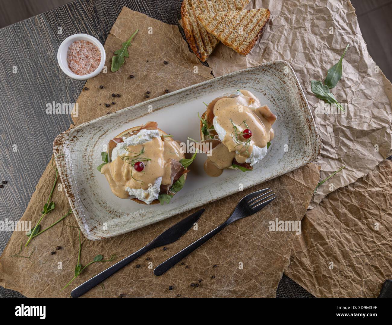 Vista dall'alto delle uova benedict con uova in camicia, prosciutto e salsa hollandaise Foto Stock