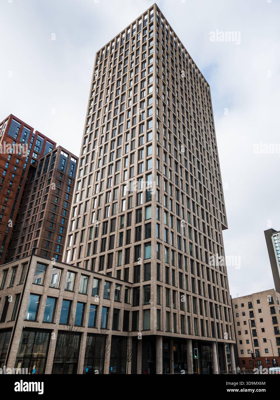 Alta torre residenziale e commerciale contemporanea nel centro di Manchester che presenta una moderna architettura urbana contro un cielo coperto Foto Stock