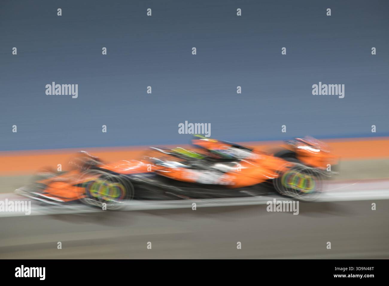 Le auto da corsa veloci scendono in pista durante l'evento del Gran Premio del Qatar 2025 tenutosi a Lusail, con luci accese che illuminano la scena Foto Stock