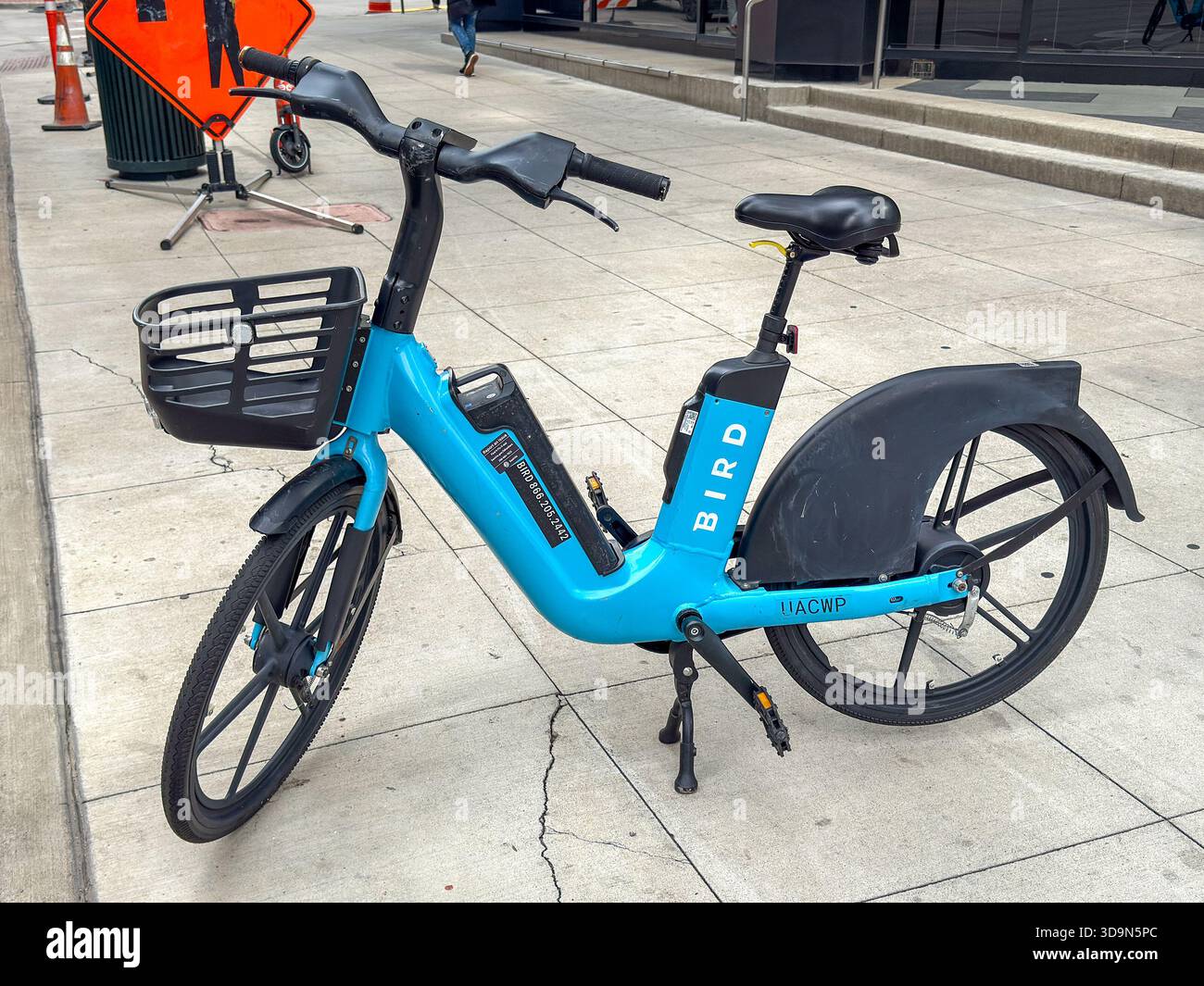 Denver, Colorado, USA - 4 giugno 2025: Bici elettrica del sistema di condivisione biciclette Bird lasciata incustodita su un marciapiede nel centro di Denver. - Immagine stock catturata con smartphone