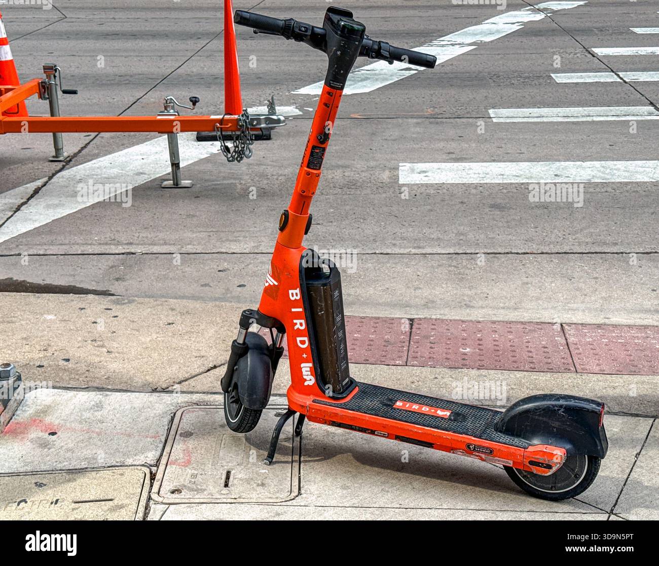 Denver, Colorado, USA - 4 giugno 2025: Scooter elettrico del sistema di condivisione degli uccelli lasciato incustodito su un marciapiede nel centro di Denver. - Immagine stock catturata con smartphone