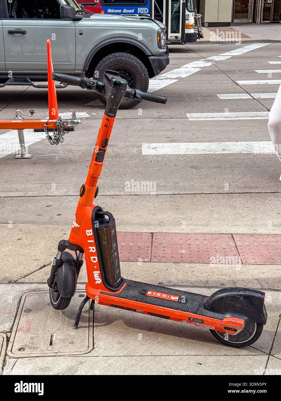 Denver, Colorado, USA - 4 giugno 2025: Scooter elettrico del sistema di condivisione degli uccelli lasciato incustodito su un marciapiede nel centro di Denver. - Immagine stock catturata con smartphone