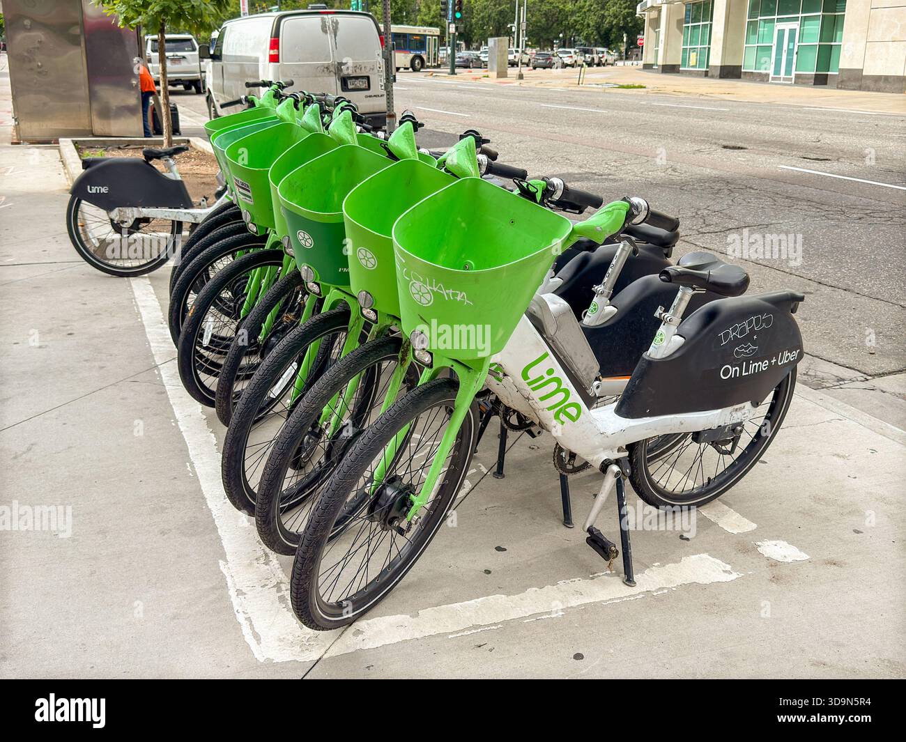Denver, Colorado, USA - 4 giugno 2025: Biciclette elettriche del sistema di condivisione biciclette Lime Bike lasciate incustodite su un marciapiede nel centro di Denver. - Immagine stock catturata con smartphone