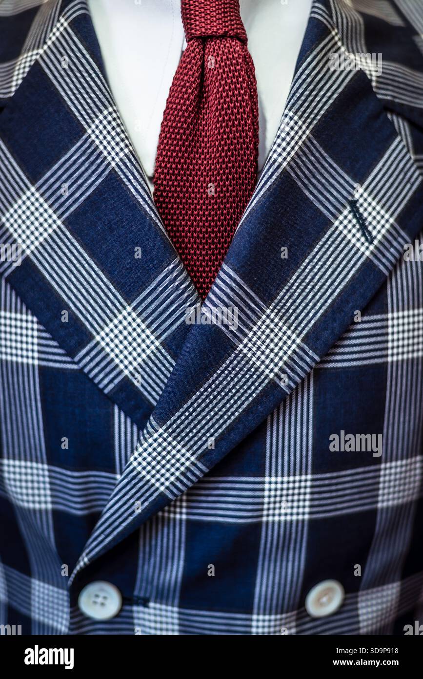 Dettaglio di una giacca da completo su misura a doppio petto (in un motivo a quadri larghi o scozzese blu), cravatta rossa e camicia bianca Foto Stock