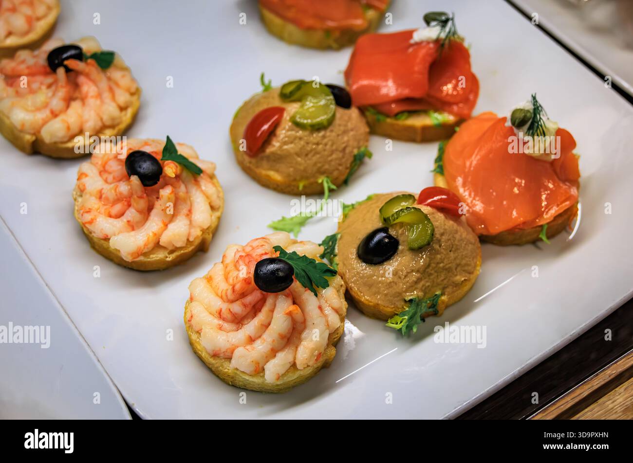 Panini a vista Belegte Brotli con gamberetti, insalata di tonno e salmone affumicato su un piatto bianco da portata in vendita in una panetteria di Zurigo, Svizzera Foto Stock