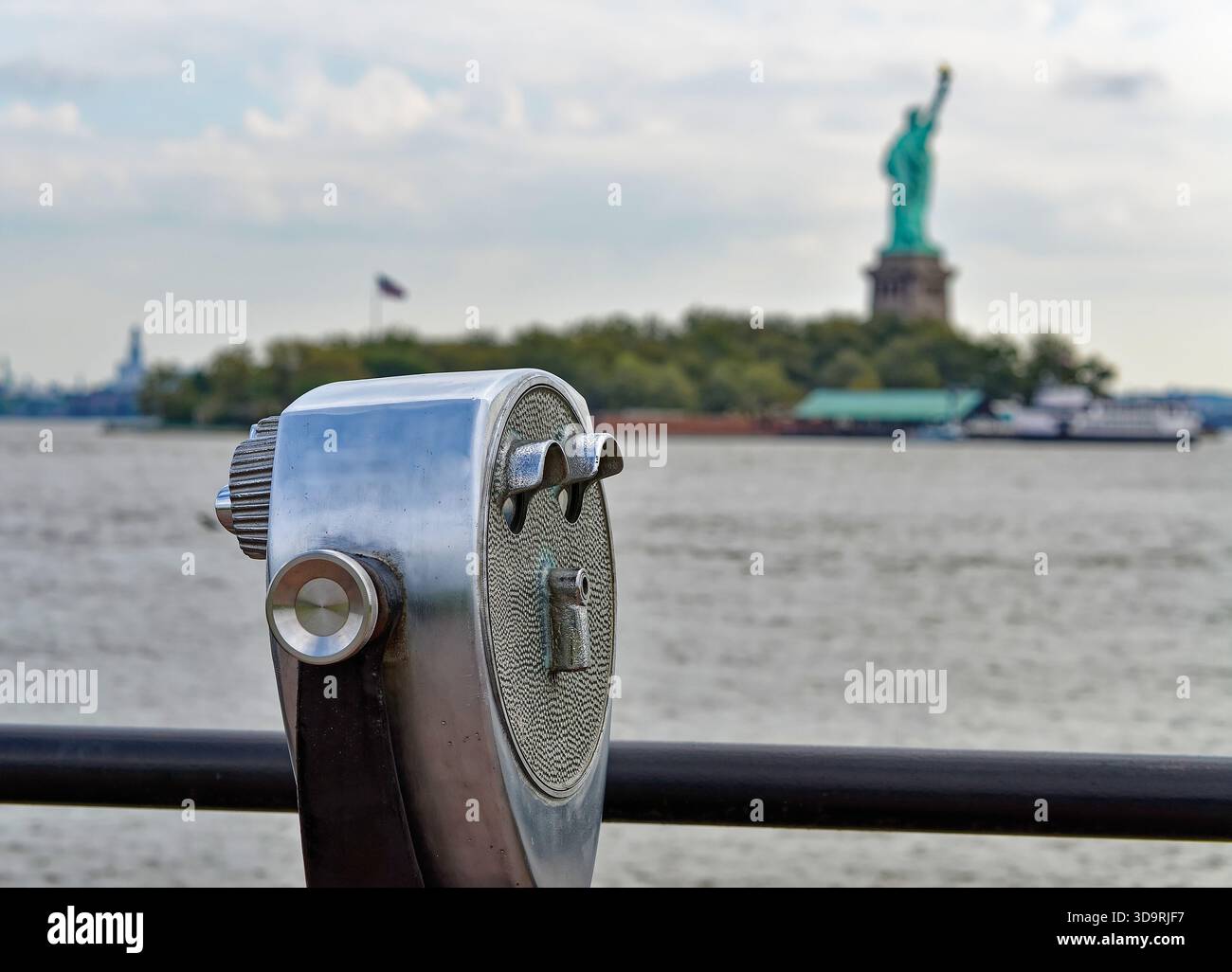 I binocoli turistici puntano verso la Statua della libertà attraverso il mare a New York, New York, negli Stati Uniti, sotto un cielo luminoso, che simboleggia l'osservazione, la libertà e l'ic Foto Stock