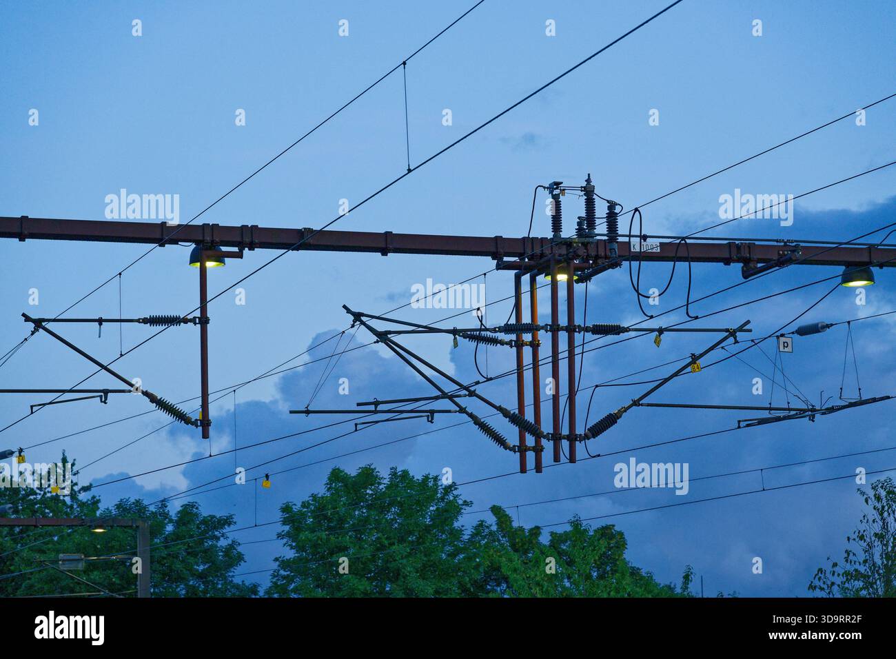 Una traversa del tubo trasversale collega due poli sopra le guide e trasporta la bulloneria della catenaria. Le fascette, i bulloni e gli isolatori si allineano lungo l'apertura come struttura Foto Stock