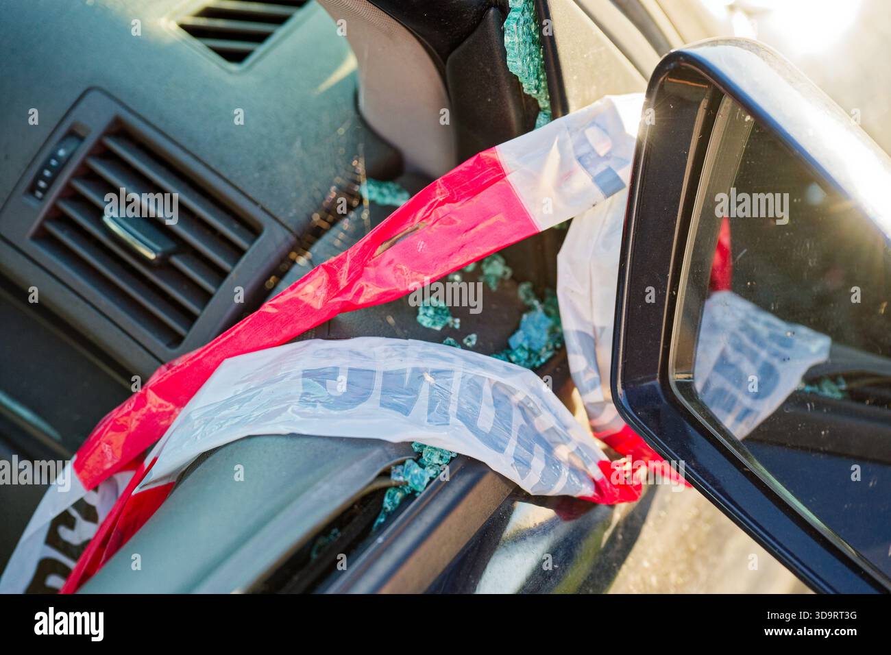 Lo specchietto laterale è avvolto con nastro rosso bianco mentre i cristalli frantumati si aggrappano al telaio del finestrino, piccoli frammenti coprono la vernice e sigillano, l'auto ti aspetta Foto Stock
