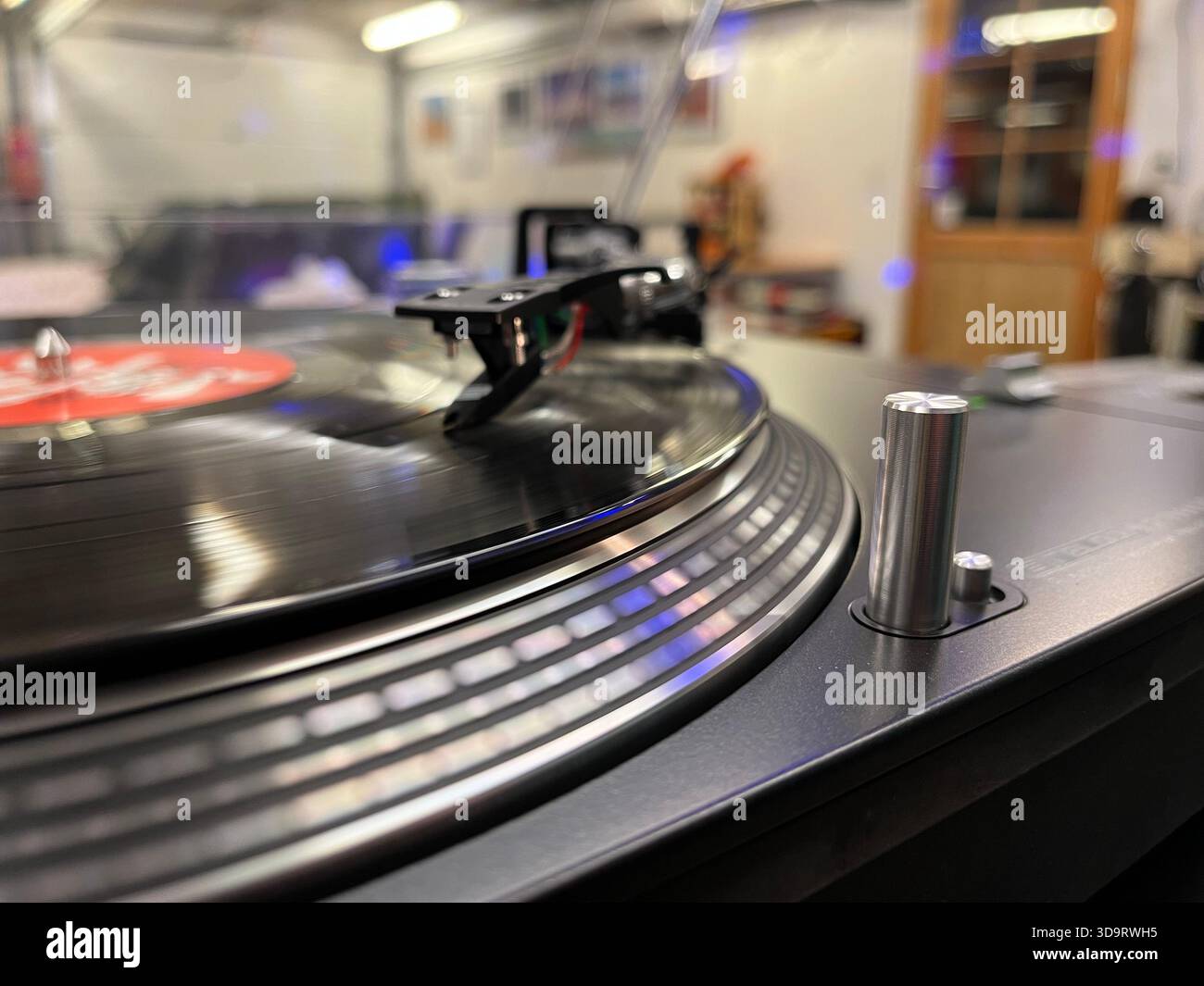 Vista ravvicinata di un lettore di dischi in vinile con un disco rotante. Il giradischi è dotato di un piatto nero e di un braccio stilo, che catturano l'essenza del ret Foto Stock