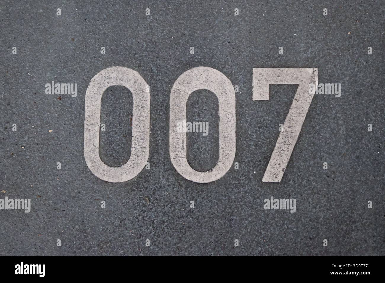 Il numero 007 dipinto su una superficie grigia testurizzata, simboleggia il mistero e l'intrigo di james Bond. Foto Stock