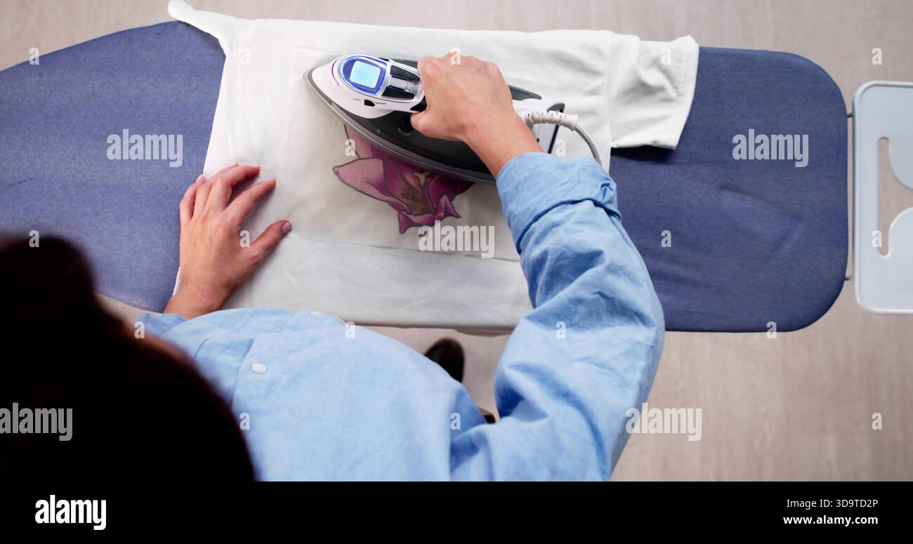 Creazione di T-shirt personalizzate con la stampante per il trasferimento del ferro a casa. Foto Stock