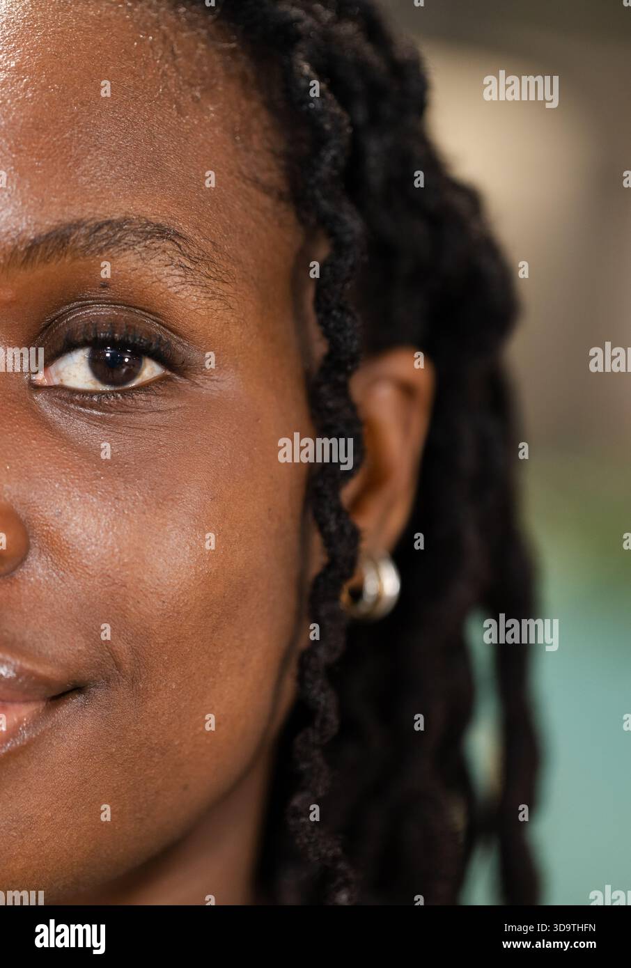 Metà sinistra del volto femminile che mostra la consistenza della pelle, i punti ritorti e il cerchio d'argento in studio Foto Stock