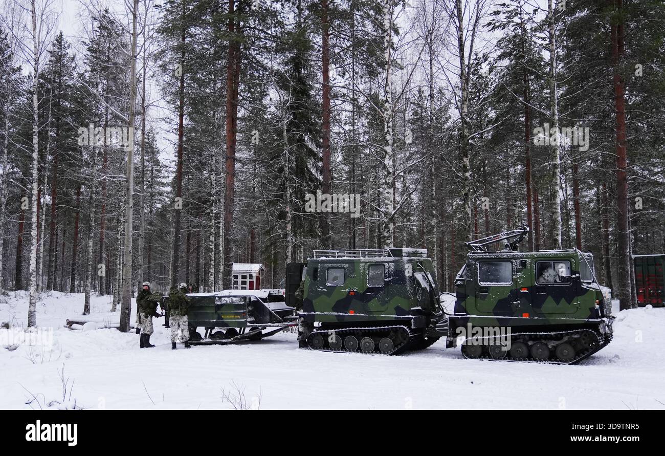 Membri dell'esercito finlandese a Vuosanka vicino a Kajaani mentre i soldati britannici si addestrano durante un'esercitazione sul confine della NATO con la Russia. Una compagnia di 3 Rifles, con sede a Edimburgo, ha trascorso sei settimane di formazione nel nord della Finlandia, durante le quali hanno affinato le loro abilità di sopravvivenza a temperature fino a meno di 28C. Data foto: Martedì 2 dicembre 2025. Foto Stock