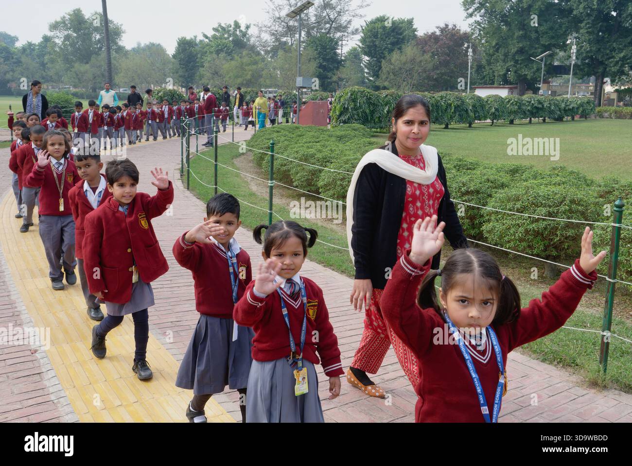 Un insegnante a Kushinagar, Uttar Pradesh, India, conduce i bambini delle scuole al Parinirvana Stupa, un edificio buddista che segna il luogo della morte di Buddha Foto Stock