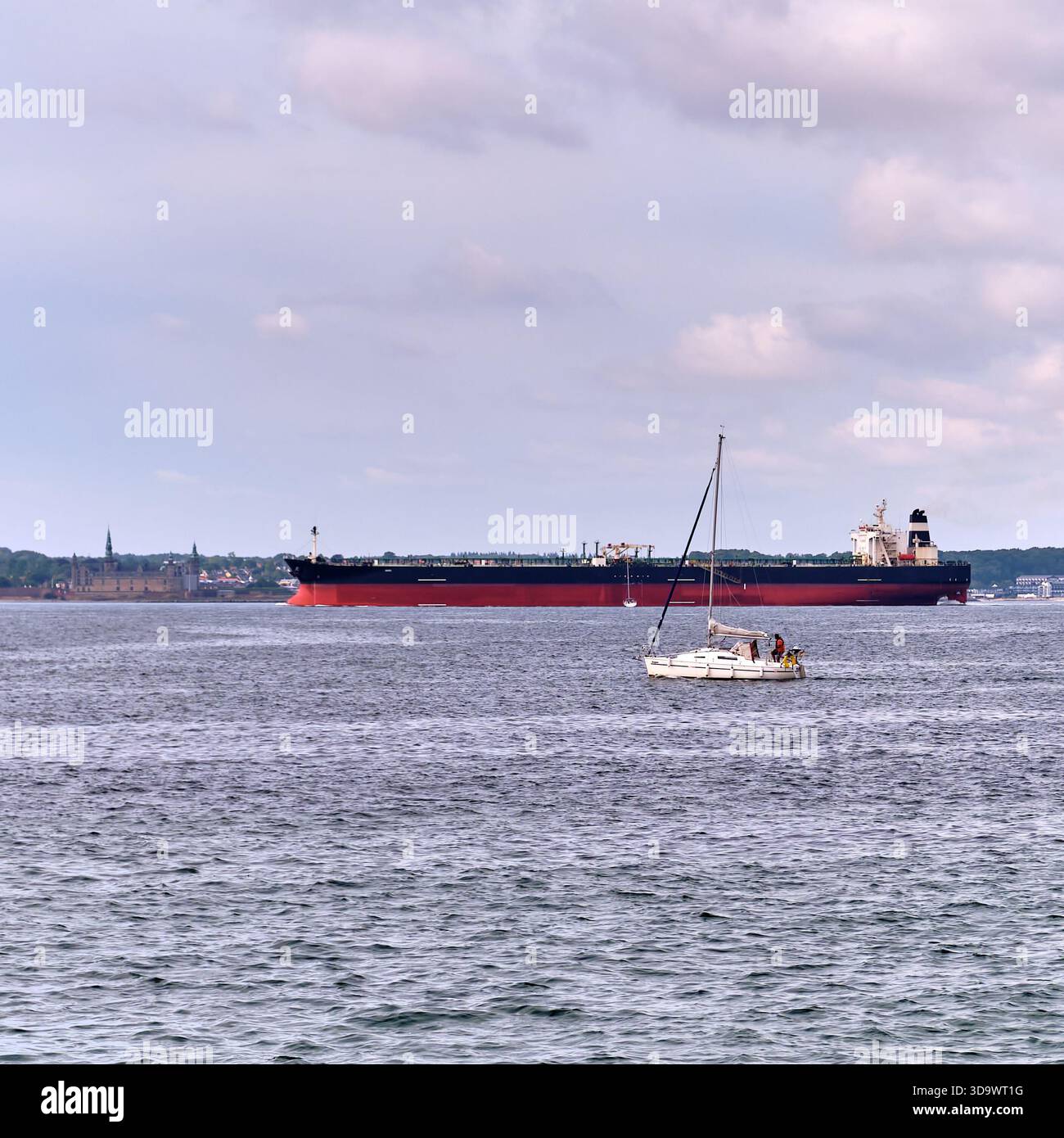 HELSINGBORG, Skåne län, SVEZIA - 12 agosto 2025: Una vista sul mare a Helsingborg Svezia presenta una grande nave petroliera e una barca a vela sull'acqua Foto Stock