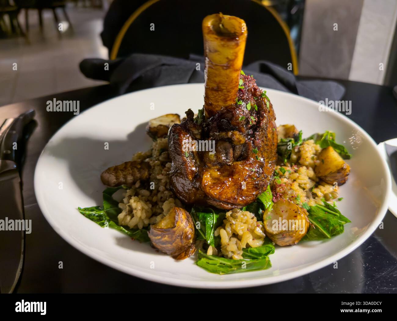 Delizioso stinco di agnello con riso, patate e spinaci. Cugino libanese. Foto Stock