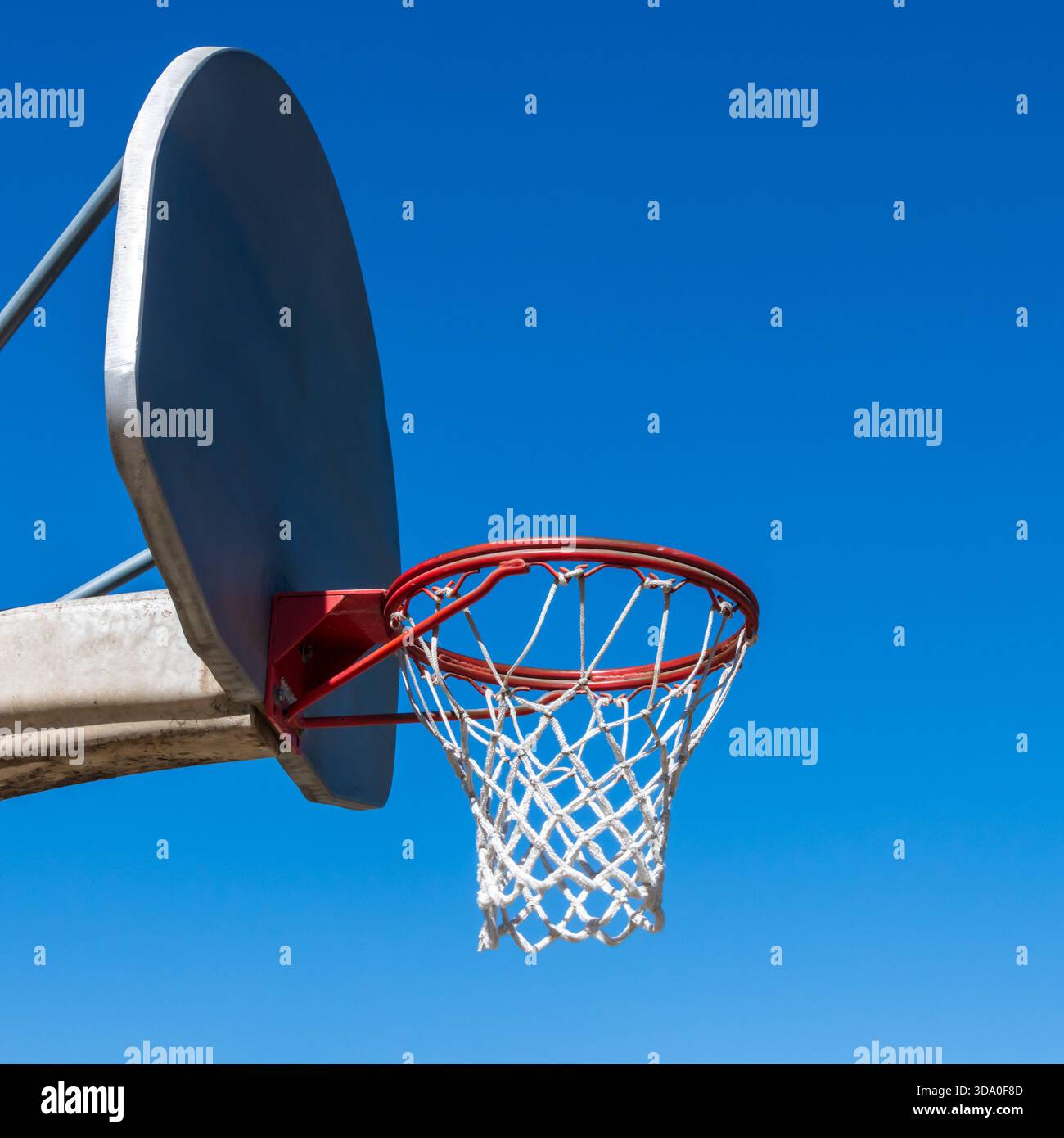 Una rete da basket all'aperto e un tabellone contro un cielo azzurro senza nuvole. Foto Stock