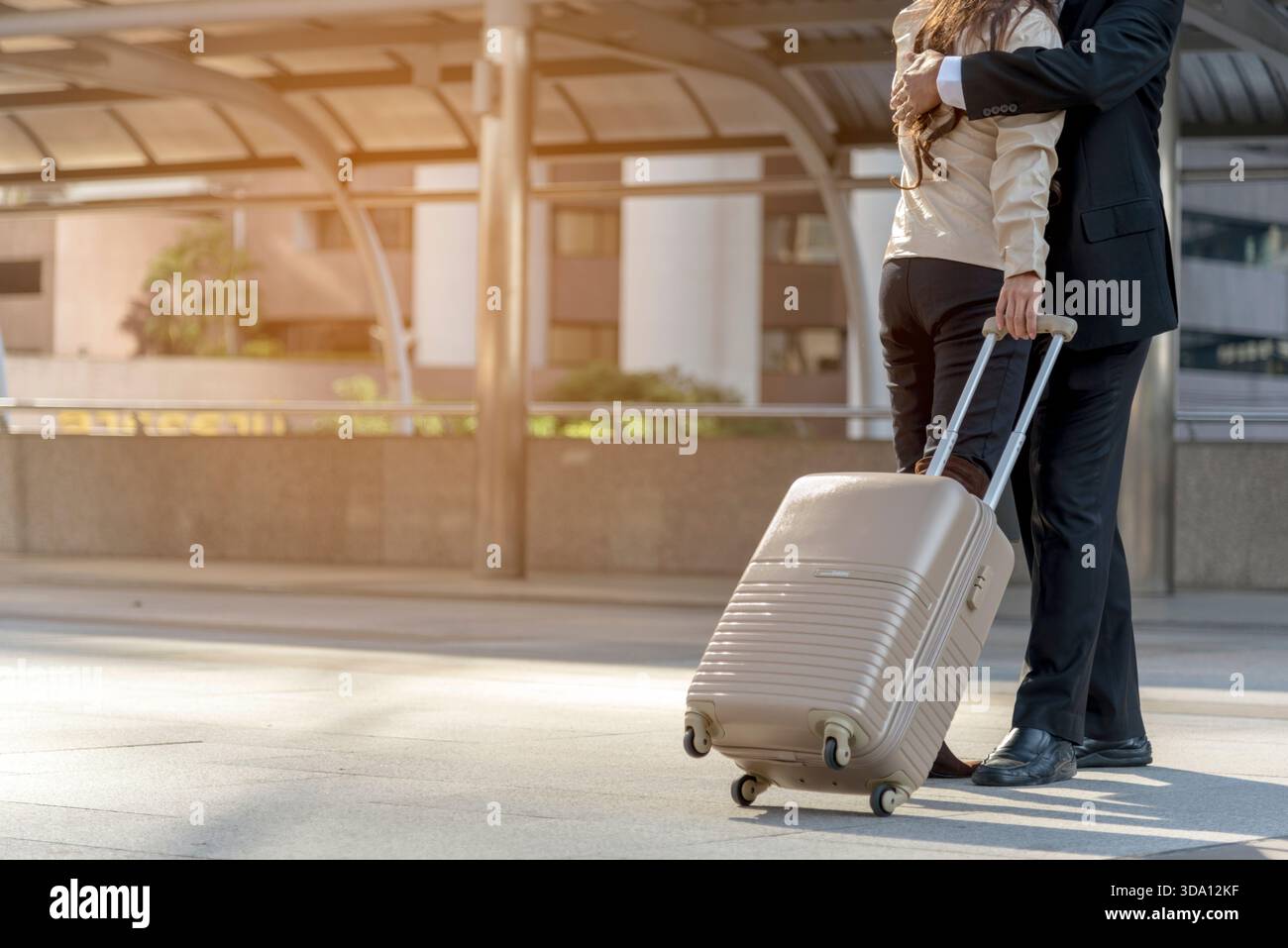 Uomini d'affari coppie amanti che camminano con i bagagli durante un viaggio d'affari. Viaggio di lavoro in luna di miele, abbracciati insieme al terminal degli arrivi a bordo. Viaggi di lavoro Foto Stock