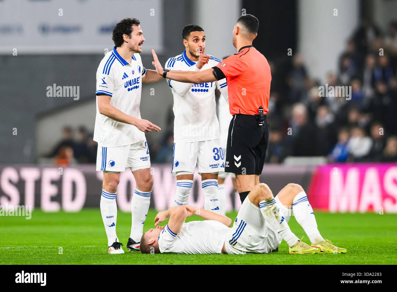 14 (FCK) - Andreas Cornelius i græsset. 27 (FCK) - Thomas Delaney og 30 (FCK) - Elias Achouri diskutere med dommer Alydin Uslu. Superliga: FC Københ Foto Stock