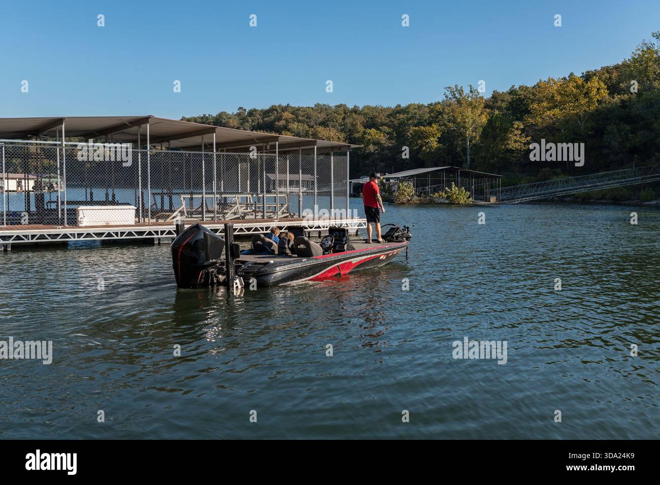 Angler e i bambini su una barca a branzino vicino a un molo nella giornata di sole Foto Stock