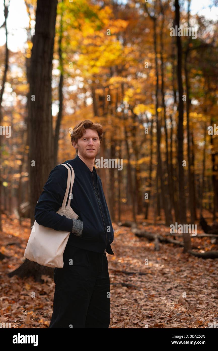 Giovane che si gode una passeggiata autunnale in una foresta colorata Foto Stock