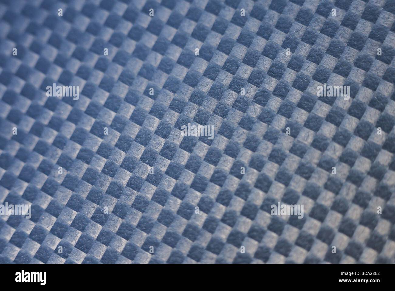 Elegante sfondo in fibra di carbonio blu con trama intrecciata. Il robusto materiale composito ha un motivo geometrico per superfici moderne, high-tech e industriali Foto Stock