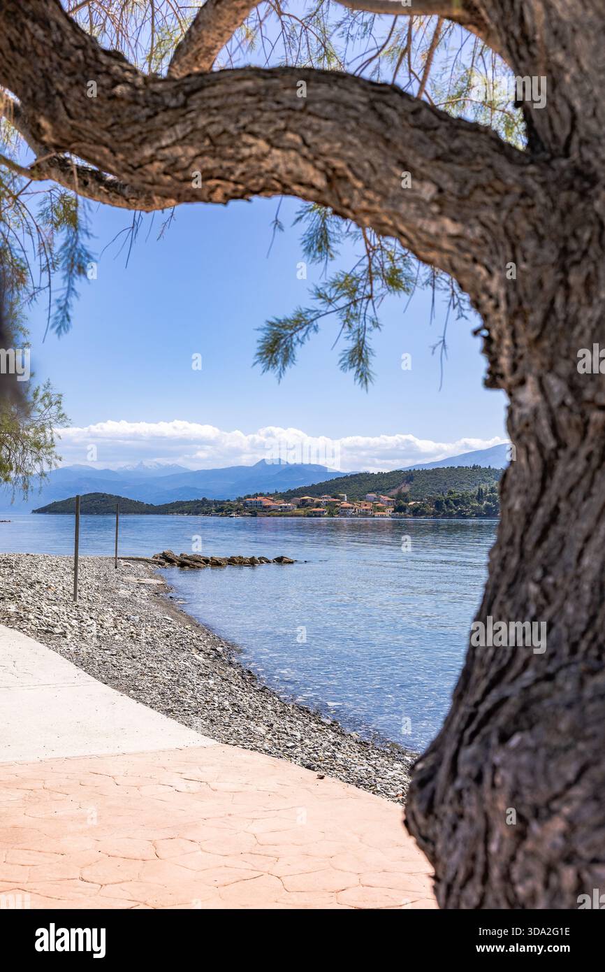 Isola di Trizonia vista dalla costa del villaggio di Glyfada nel Golfo di Corinto, Grecia. Panorama marino con acqua turchese, litorale naturale, AN Foto Stock