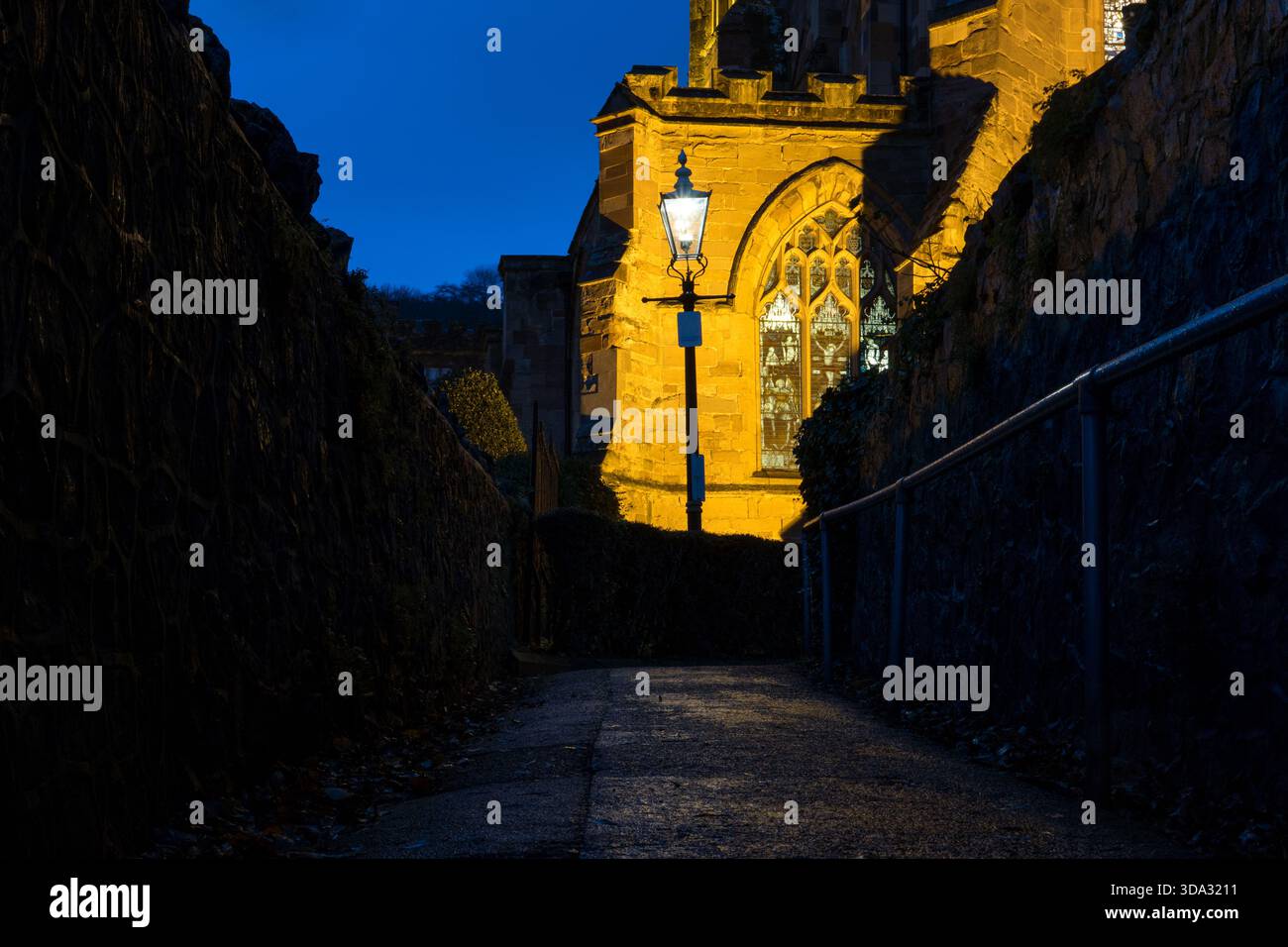 Un Priorato e un lampione vittoriano che si illumina in una serata d'inverno, Malvern Regno Unito. Foto Stock