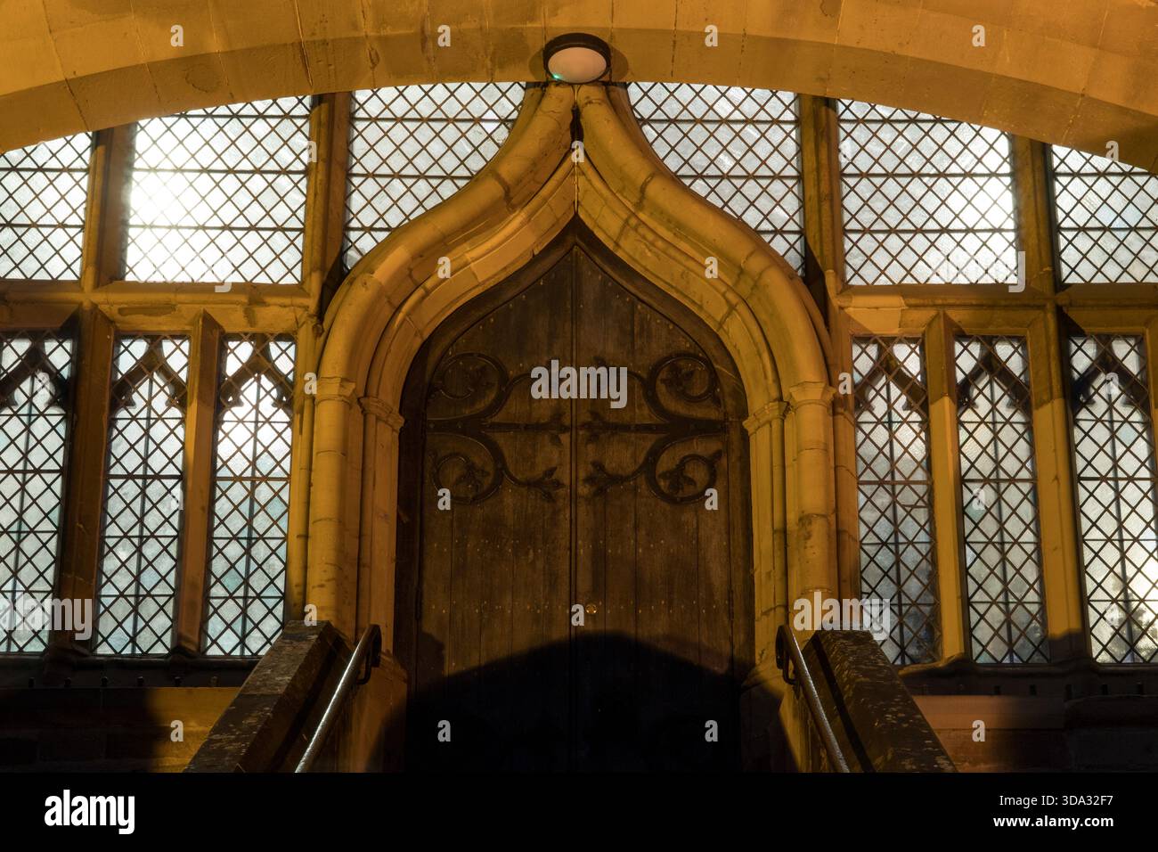 Una porta vittoriana in un priorato, con finestre che si illuminano in una serata d'inverno, Malvern UK. Foto Stock