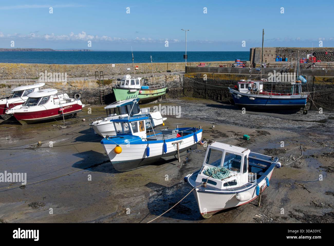 Slade, Irlanda - settembre 2025; porto di pesca sulla penisola di Hook con barche da pesca ancorate con la bassa marea sullo scivolamento di fango nel porto noto per SLA Foto Stock