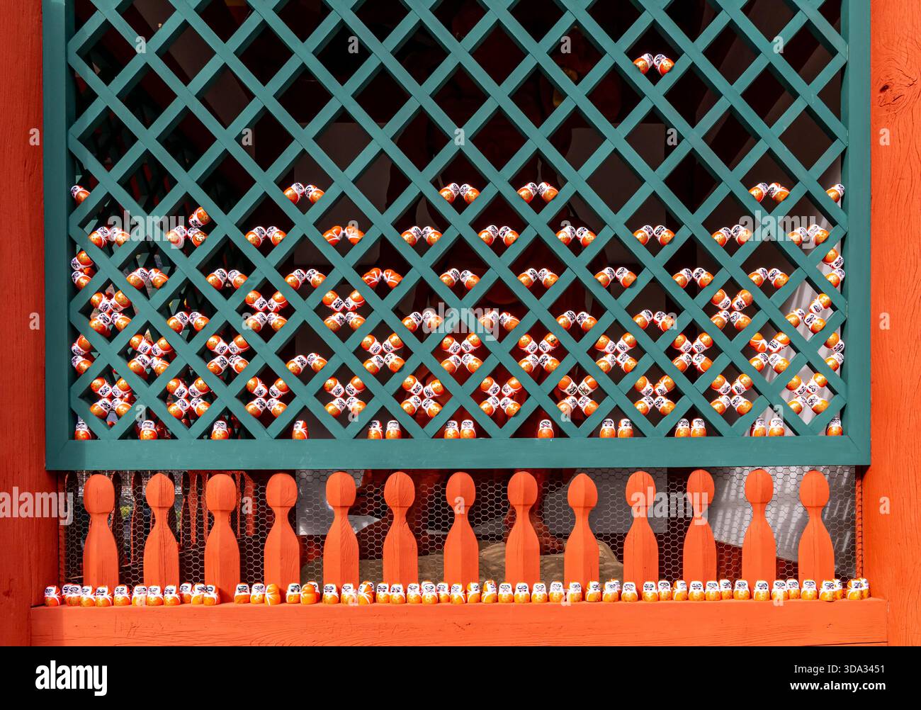 Piccole figure colorate sono disposte con cura su una struttura in legno con un motivo a griglia. La scena mostra le figure inserite all'interno di una cornice colorata. Foto Stock