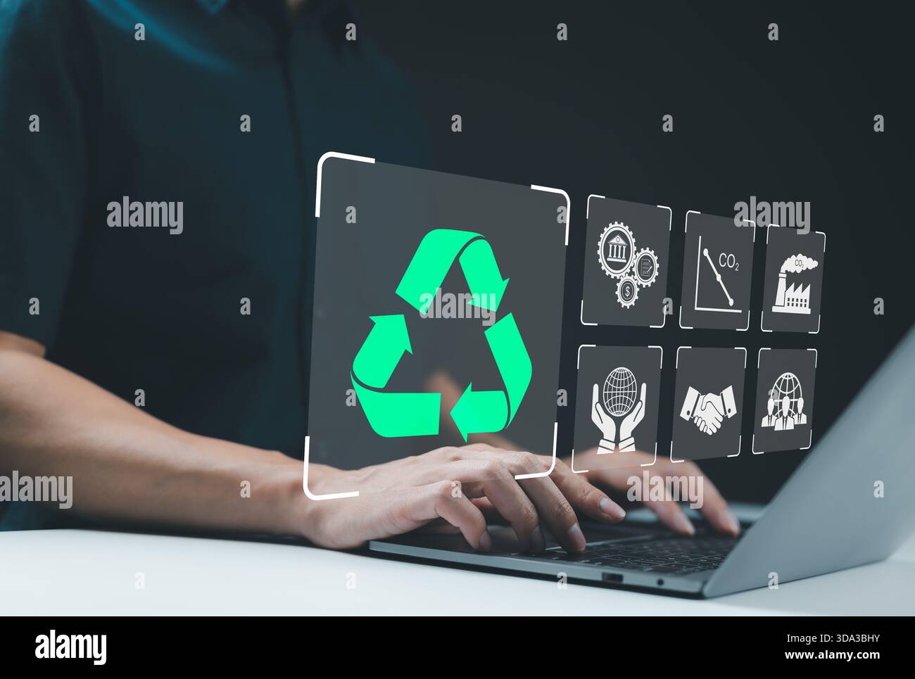 Icona del riciclo, concetto di sviluppo sostenibile. Persona che utilizza un notebook con icona di riciclaggio, circondata da vari simboli di sostenibilità, concetti di ecologia Foto Stock