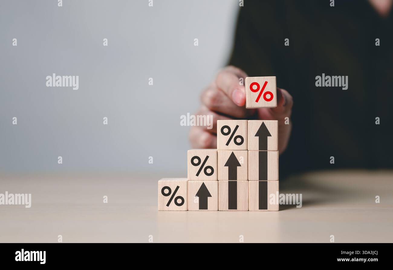 Tasso di interesse e concetto di crescita. Blocchi di legno con simboli di percentuale e frecce verso l'alto impilati progressivamente, che rappresentano i tassi di interesse, financia Foto Stock