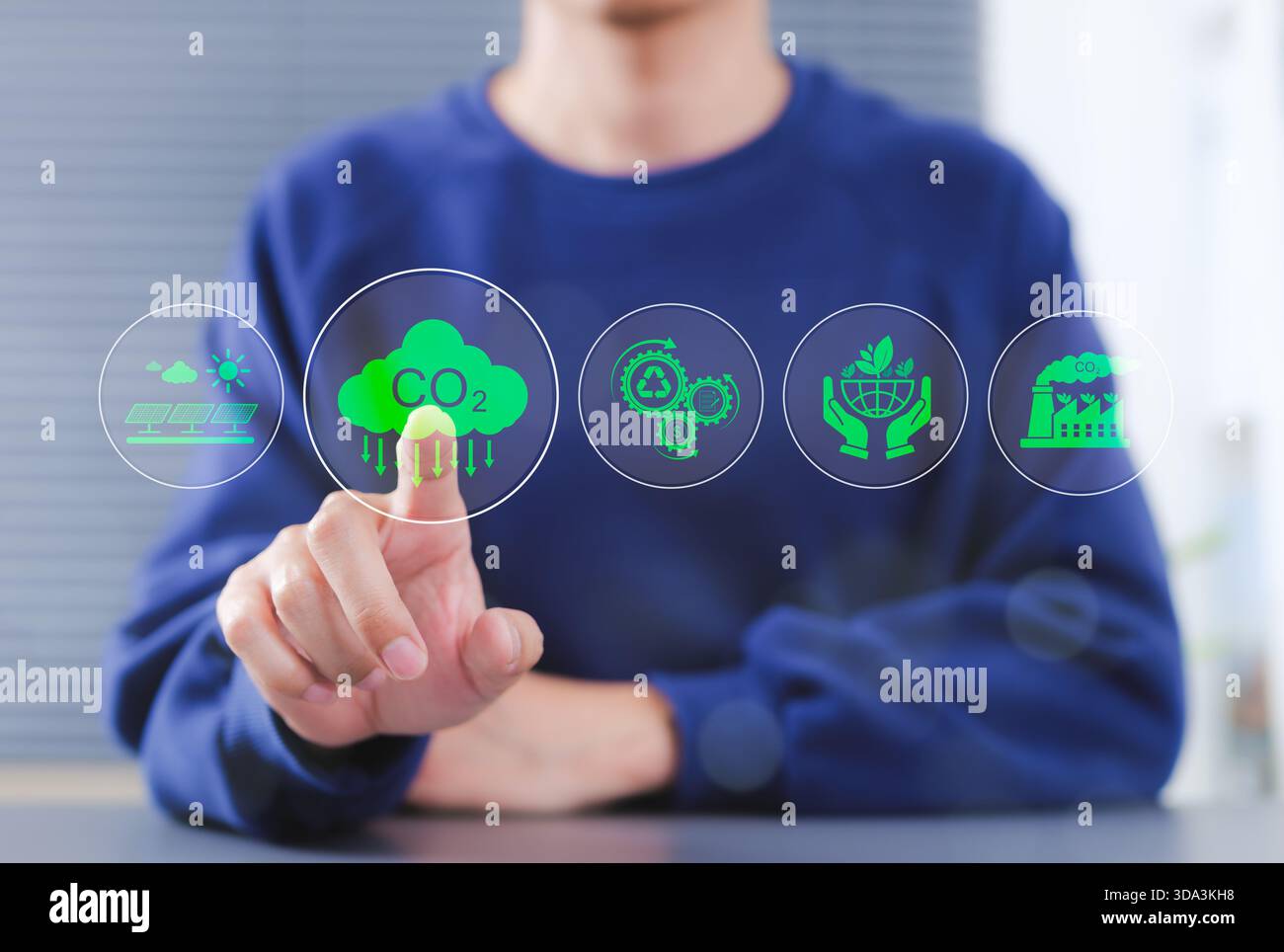 Riduzione delle emissioni di CO2. Persona che indica un'icona ambientale trasparente, tra cui la riduzione di CO2, l'energia solare, il riciclaggio e la pratica sostenibile Foto Stock