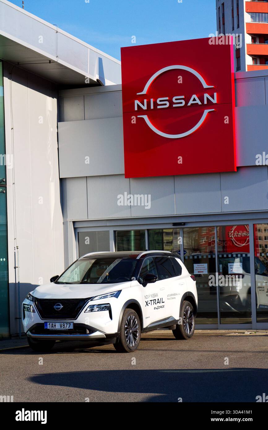 Il logo della società automobilistica Nissan di fronte all'edificio della concessionaria il 12 aprile 2025 a Praga, repubblica Ceca. Foto Stock