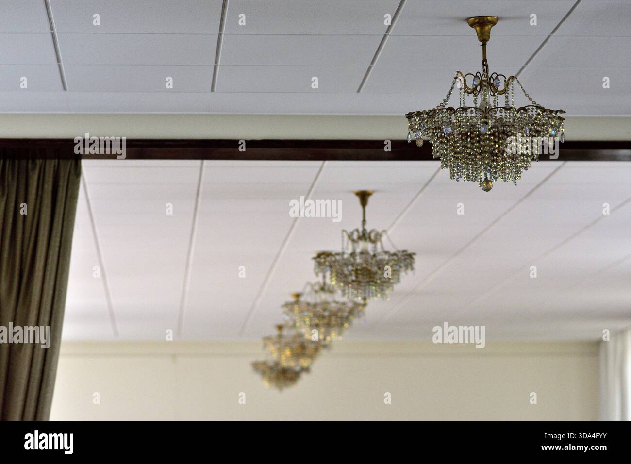 Eleganti lampadari appesi a soffitto in un ambiente formale. Foto Stock