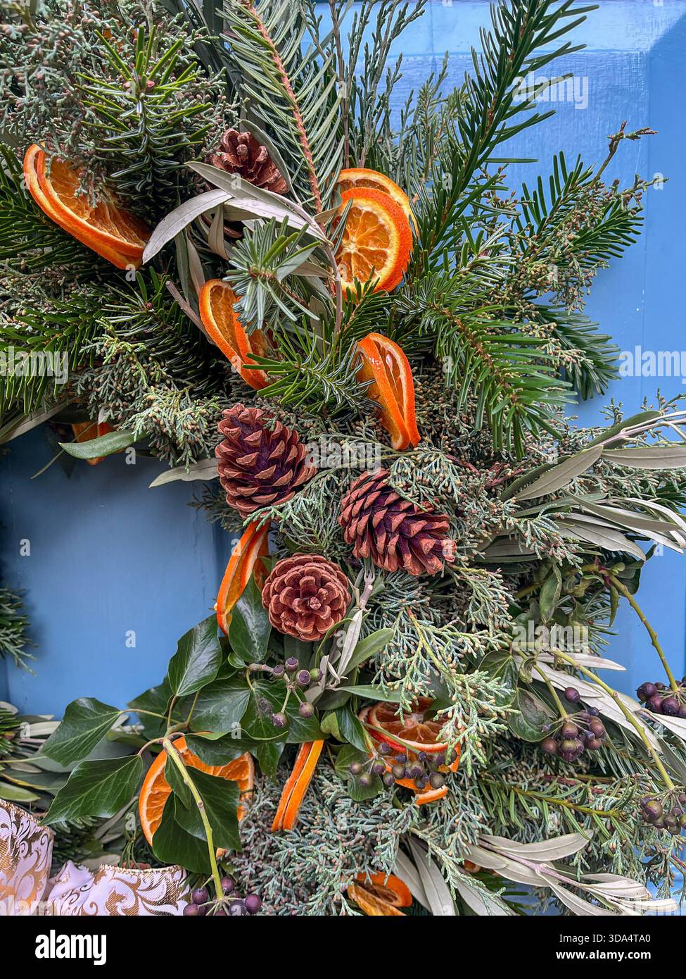 Corona natalizia con vegetazione e accenti di agrumi - Immagine stock catturata con smartphone