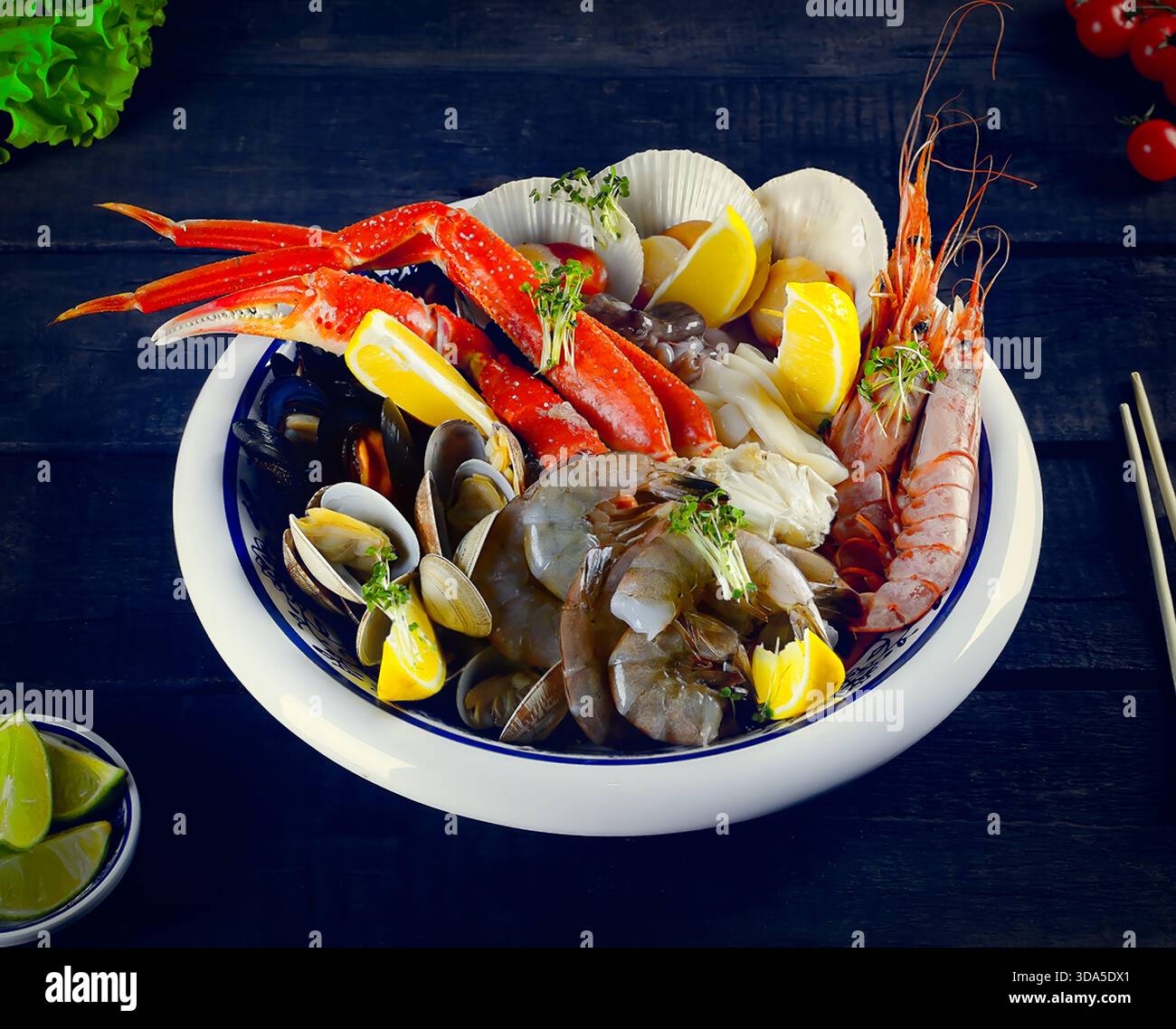 Piatto di pesce con aragosta. Un piatto di gamberetti, cozze e aragosta con fette di limone su fondo di legno blu. Foto Stock