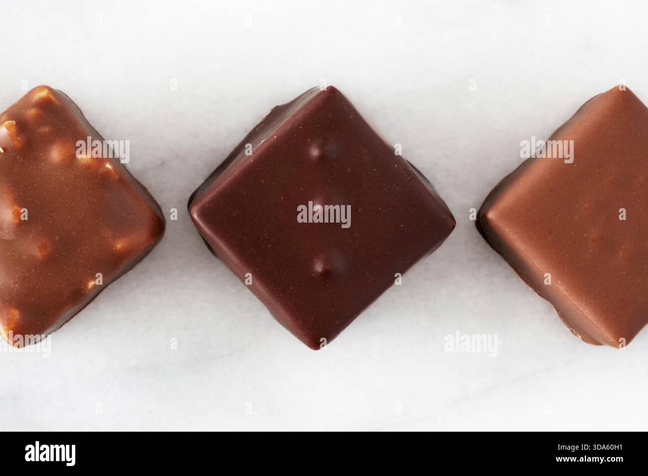 Assortimento di cioccolatini allineati su sfondo bianco Foto Stock