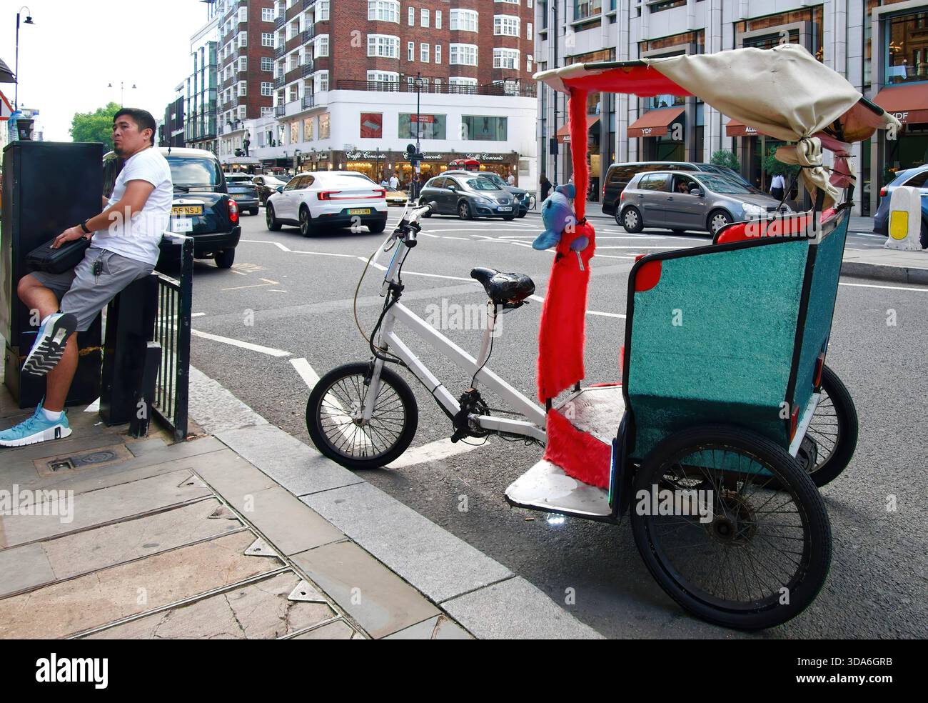 Triciclo a propulsione umana per brevi corse turistiche parcheggiato fuori dal negozio Harrods Knightsbridge Londra Inghilterra Regno Unito Europa Foto Stock