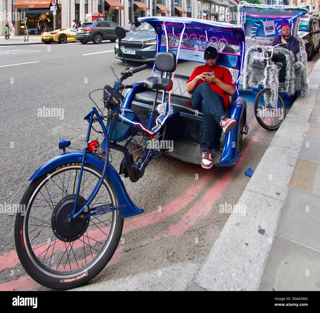 Triciclo a propulsione umana per brevi corse turistiche parcheggiato fuori dal negozio Harrods Knightsbridge Londra Inghilterra Regno Unito Europa Foto Stock