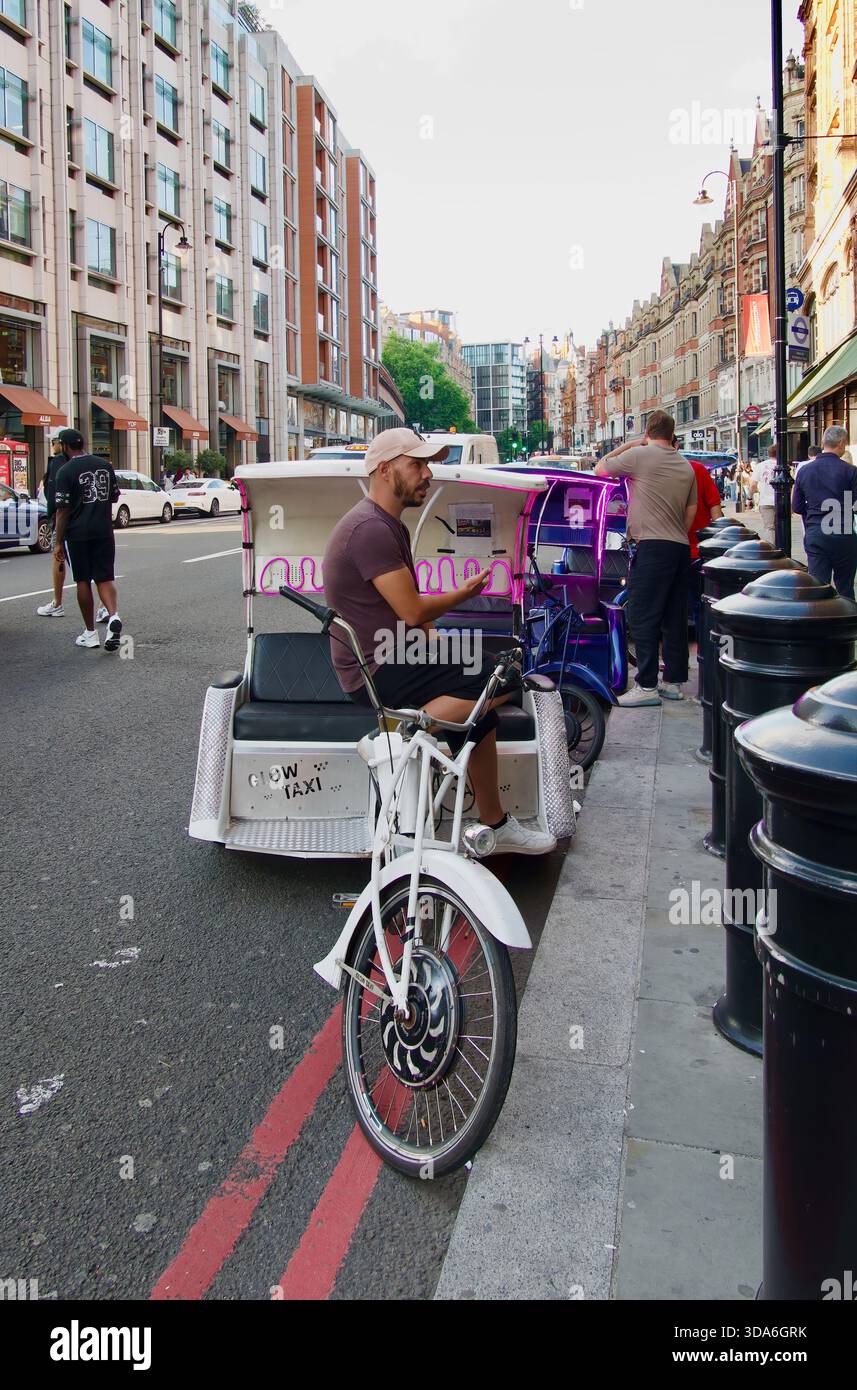 Triciclo a propulsione umana per brevi corse turistiche parcheggiato fuori dal negozio Harrods Knightsbridge Londra Inghilterra Regno Unito Europa Foto Stock