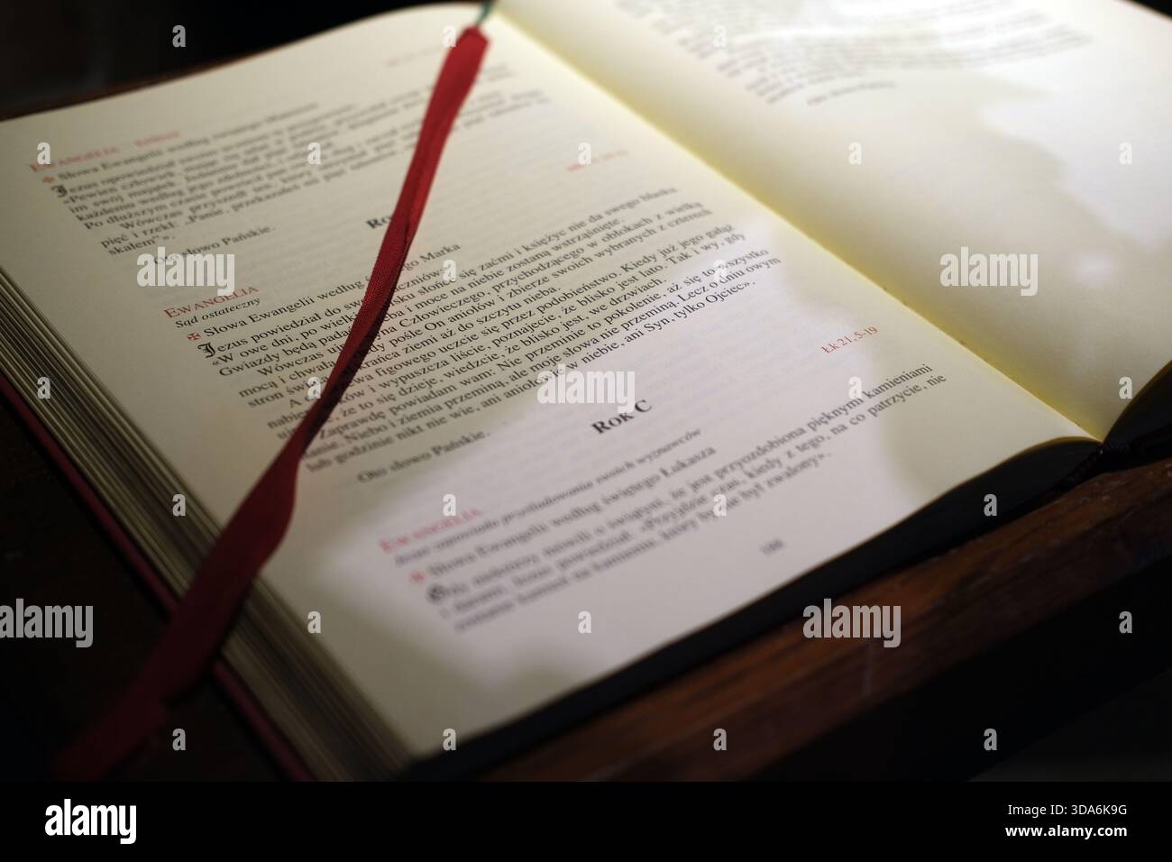 Libro liturgico aperto stampato in polacco, pagine color crema con testo serif nero e rosso, segnalibro del nastro in tessuto rosso Foto Stock