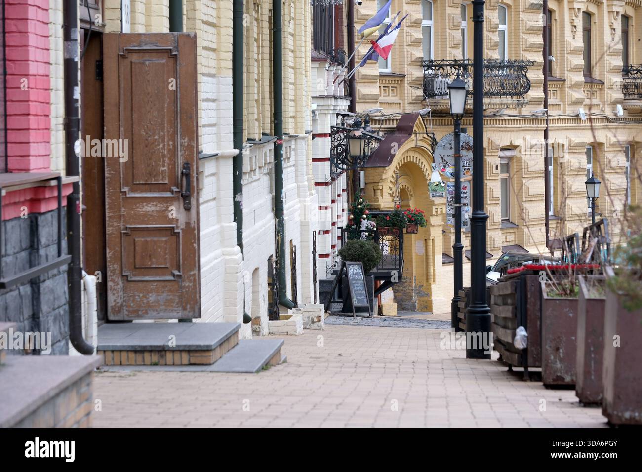 Il sentiero acciottolato conduce i visitatori attraverso edifici colorati e invitanti caffetterie. Kiev, Ucraina. 8 dicembre 2025. Foto Stock