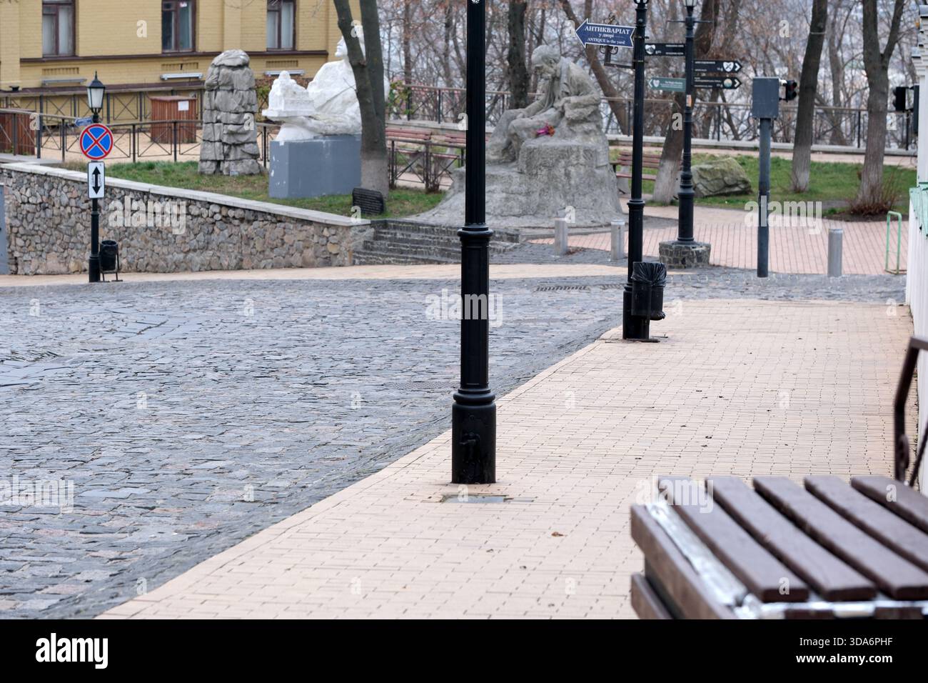 Un sentiero sereno che si snoda attraverso un parco, circondato da sculture rustiche e lampioni. Kiev, Ucraina. 8 dicembre 2025. Foto Stock