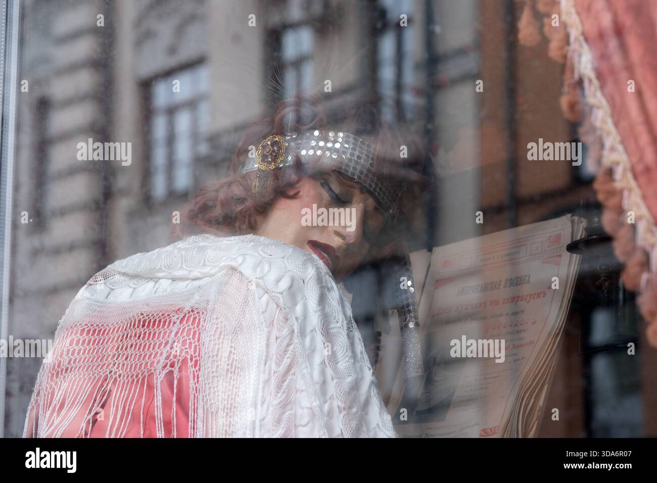 Un grazioso esecutore che vive in un'epoca passata suona un pianoforte con passione. Andreevsky Uzviz, Kiev, Ucraina. 8 dicembre 2025. Foto Stock