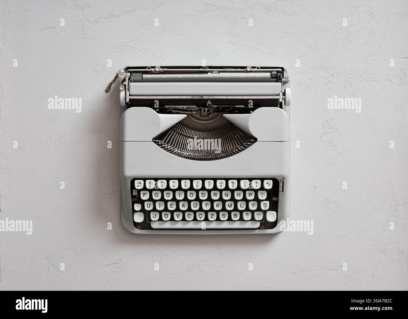 Macchina da scrivere in grigio retrò che simboleggia la narrazione, la comunicazione e la scrittura creativa. Vista dall'alto con spazio di copia Foto Stock