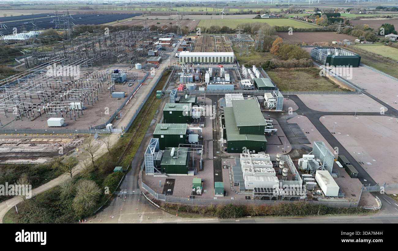 Vista aerea dell'intricata rete di linee elettriche ed edifici industriali, una sinfonia di acciaio e cemento contro il paesaggio pianeggiante, Sutton Brid Foto Stock