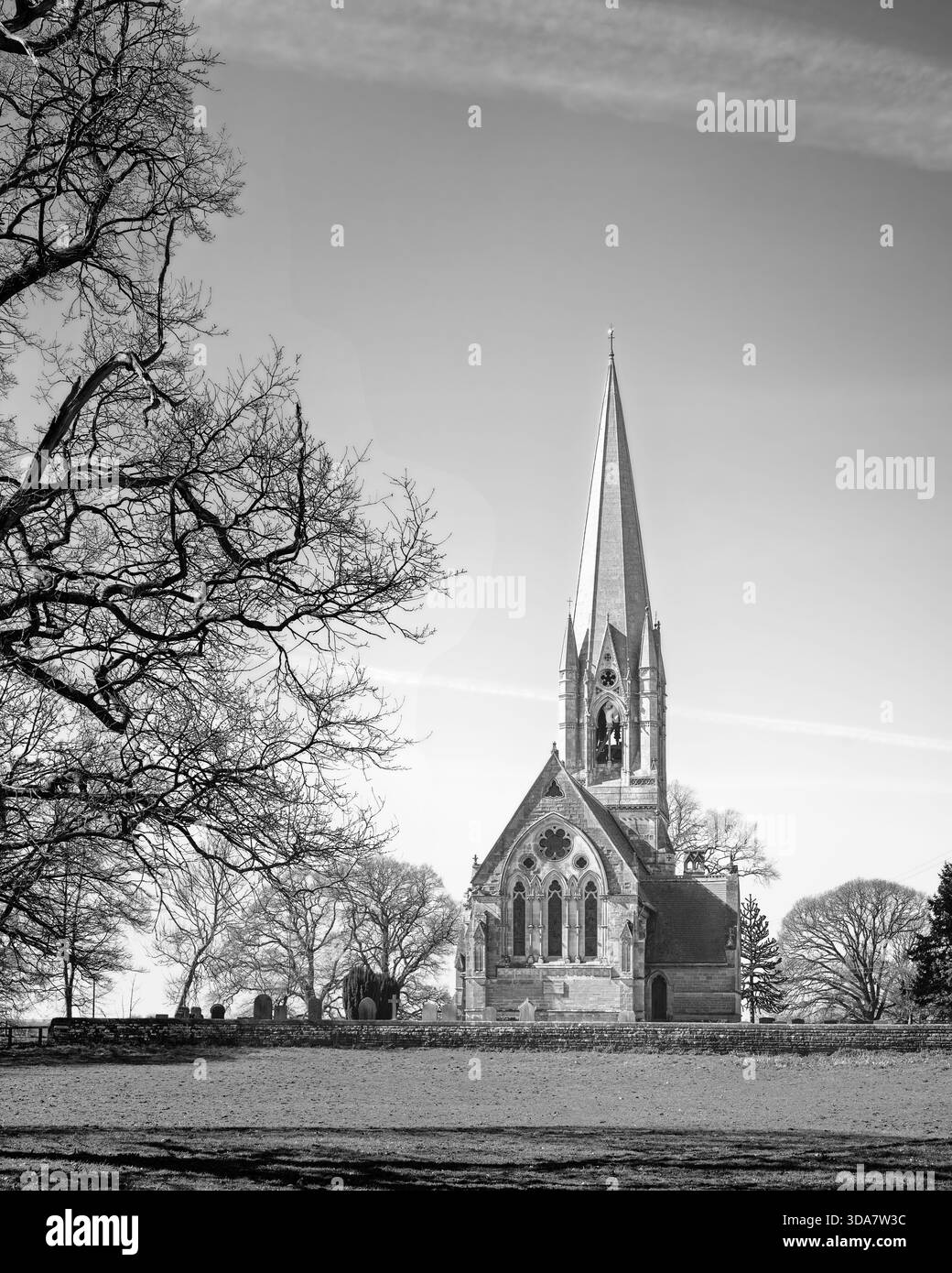 Vista dell'antica chiesa di St. Leonards fiancheggiata da alberi in una bella mattinata d'estate nel piccolo villaggio di Scorborough, Yorkshire, Regno Unito. Foto Stock
