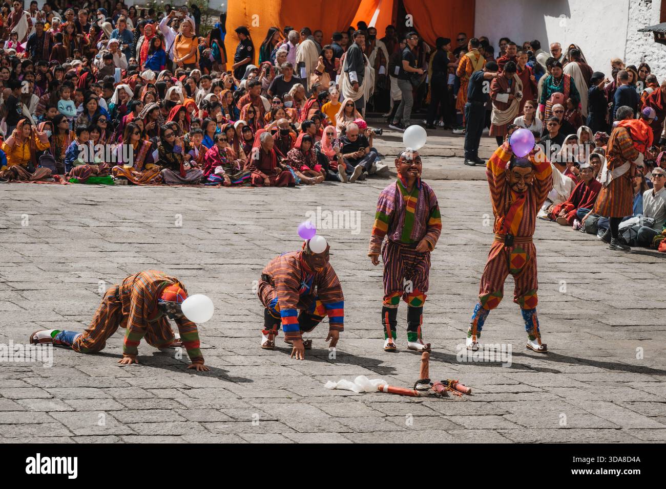 Thimphu, Bhutan - 28 settembre 2025: Veduta dei ballerini in costumi vivaci, palloncini bilanciati in mezzo al festival Thimphu Dromchoe, uno spettacolo fotografico di terra Foto Stock